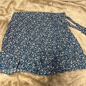 Blue floral print ruffle mini skirt with tie wrap.